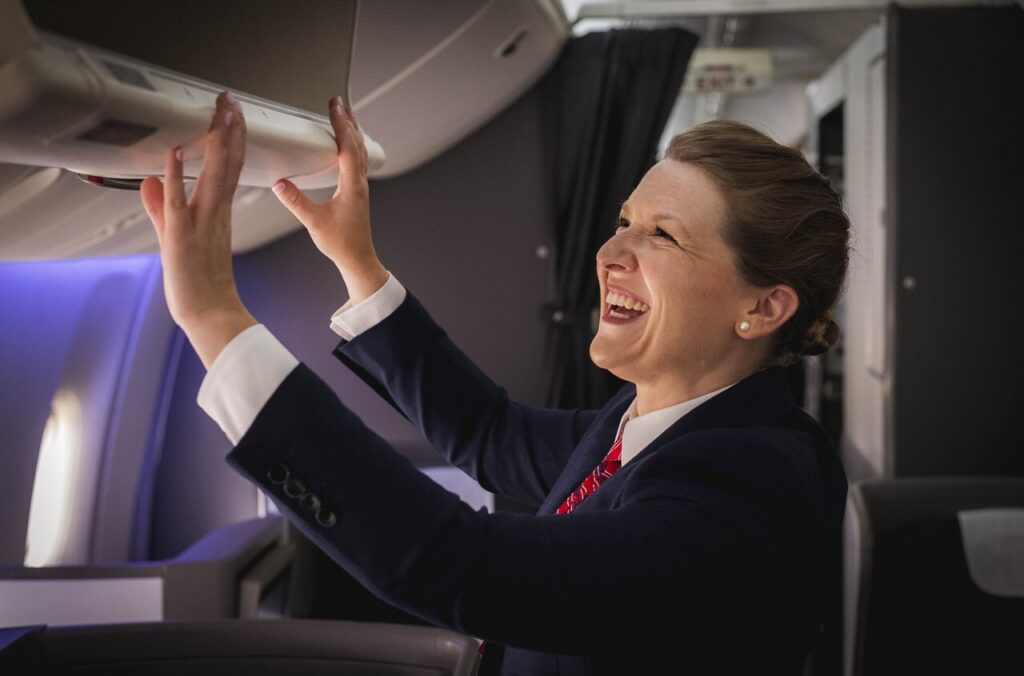 A british Airways cabin crew member closing a hat rack