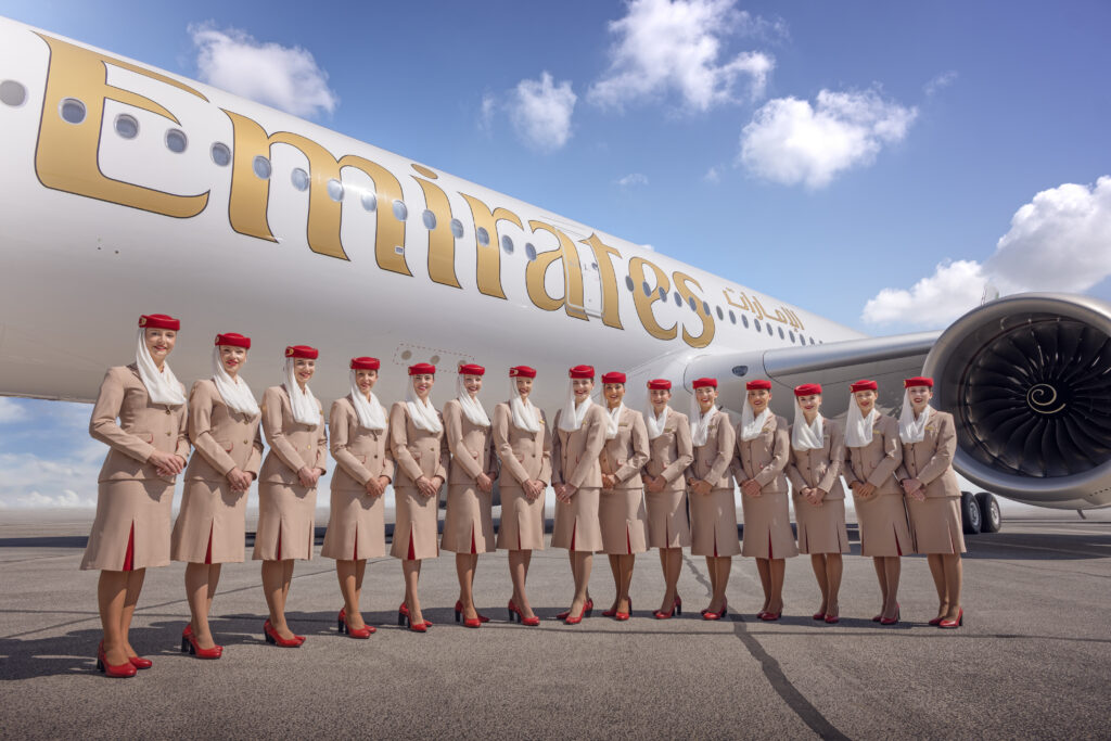 emirates cabin crew standing in front of a plane