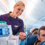 a delta air lines flight attendant serving drinks