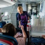 a delta air lines flight attendant serving drinks on an airplane
