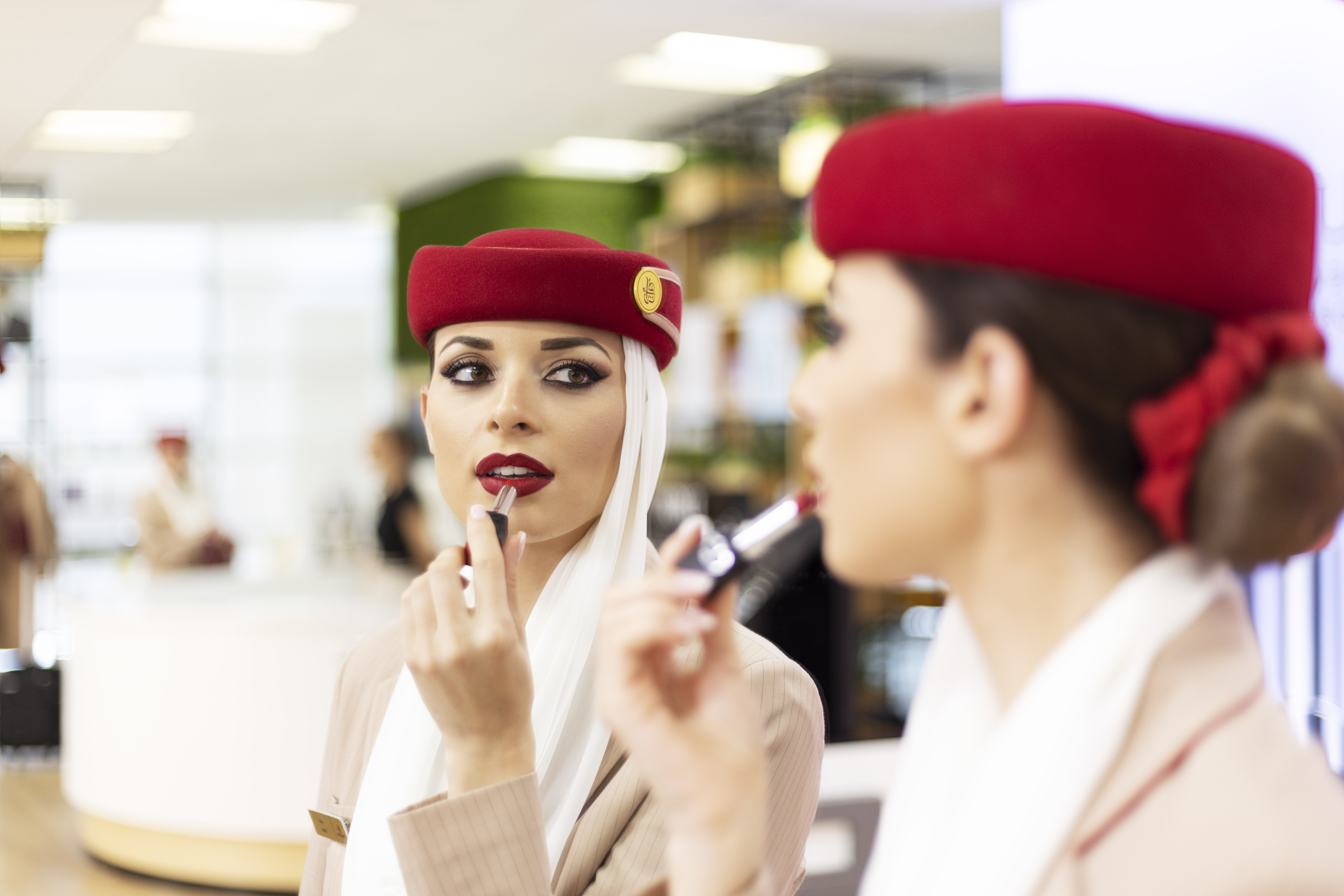 emirates cabin crew member applying lipstick