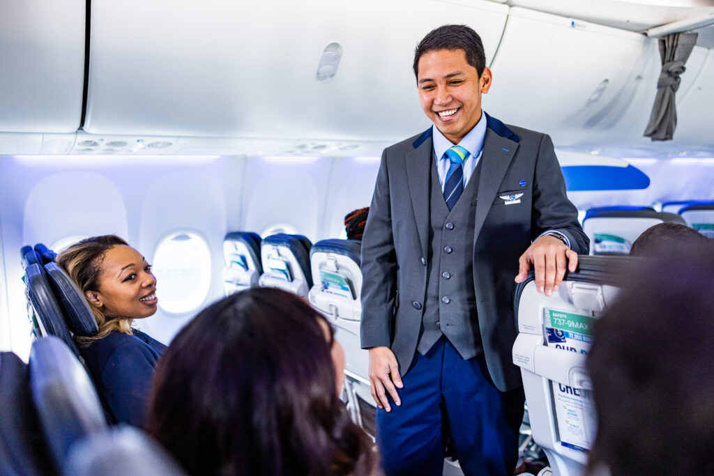 an alaska airlines flight attendant talking to passengers