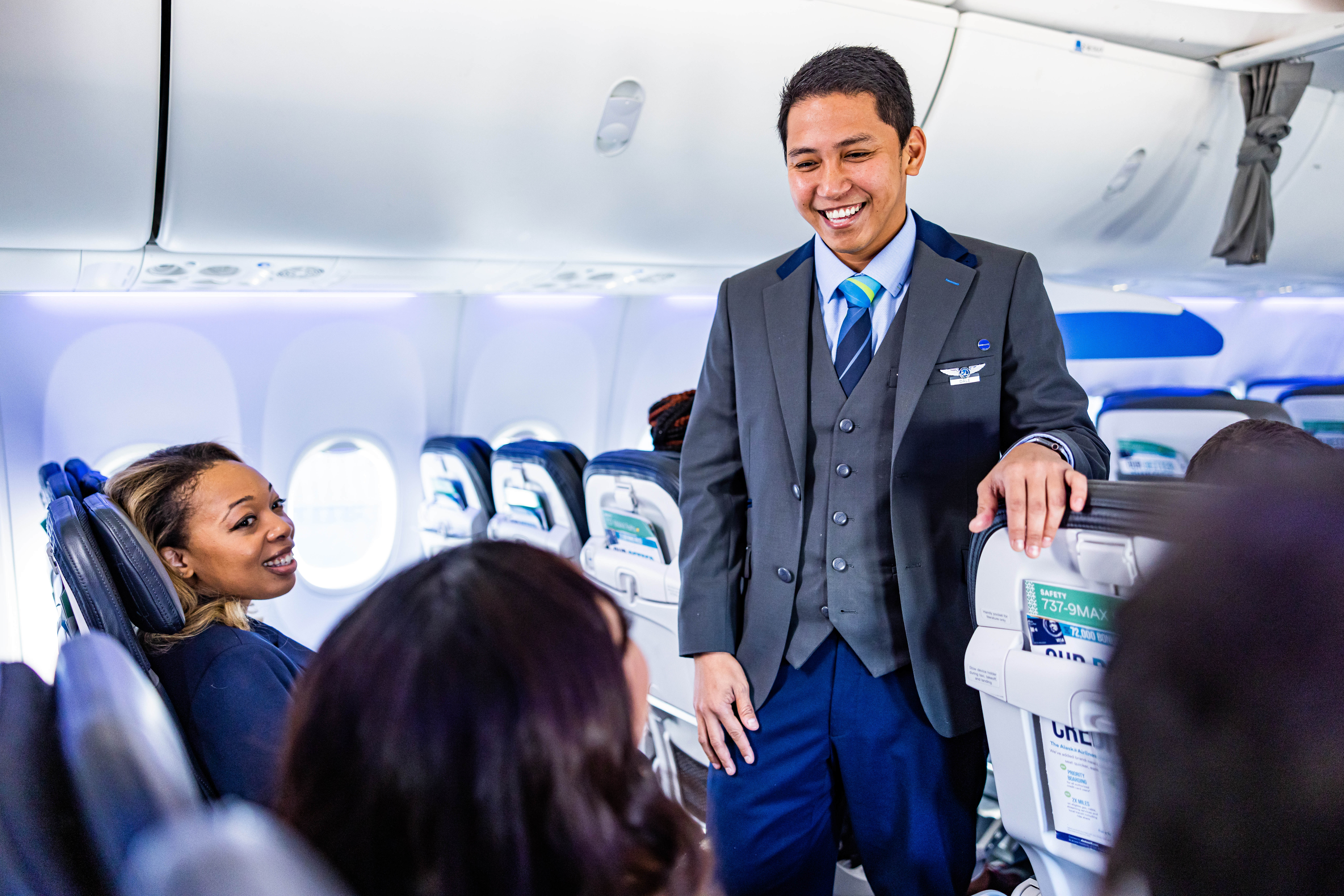 an alaska airlines flight attendant talking to passengers