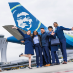 Alaska Airlines flight attendants pose in front of an Alaska Airlines plane