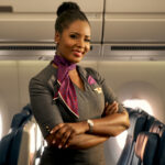 a delta flight attendant posing in the cabin