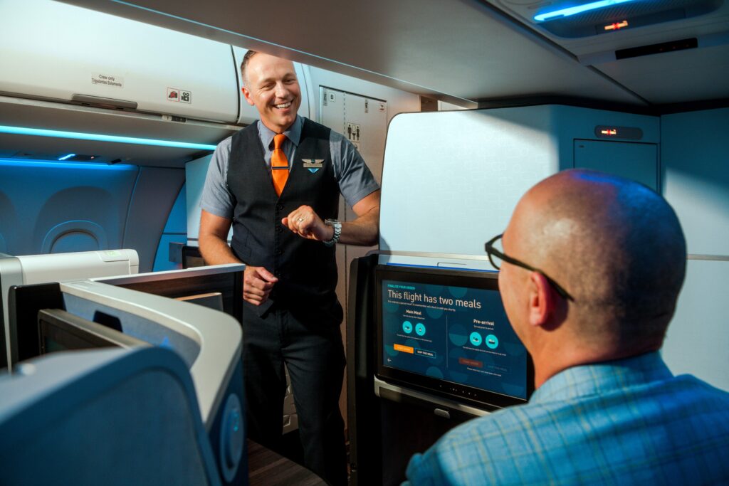 a jetblue flight attendant serving a passenger in Mint