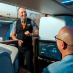 a jetblue flight attendant serving a passenger in Mint