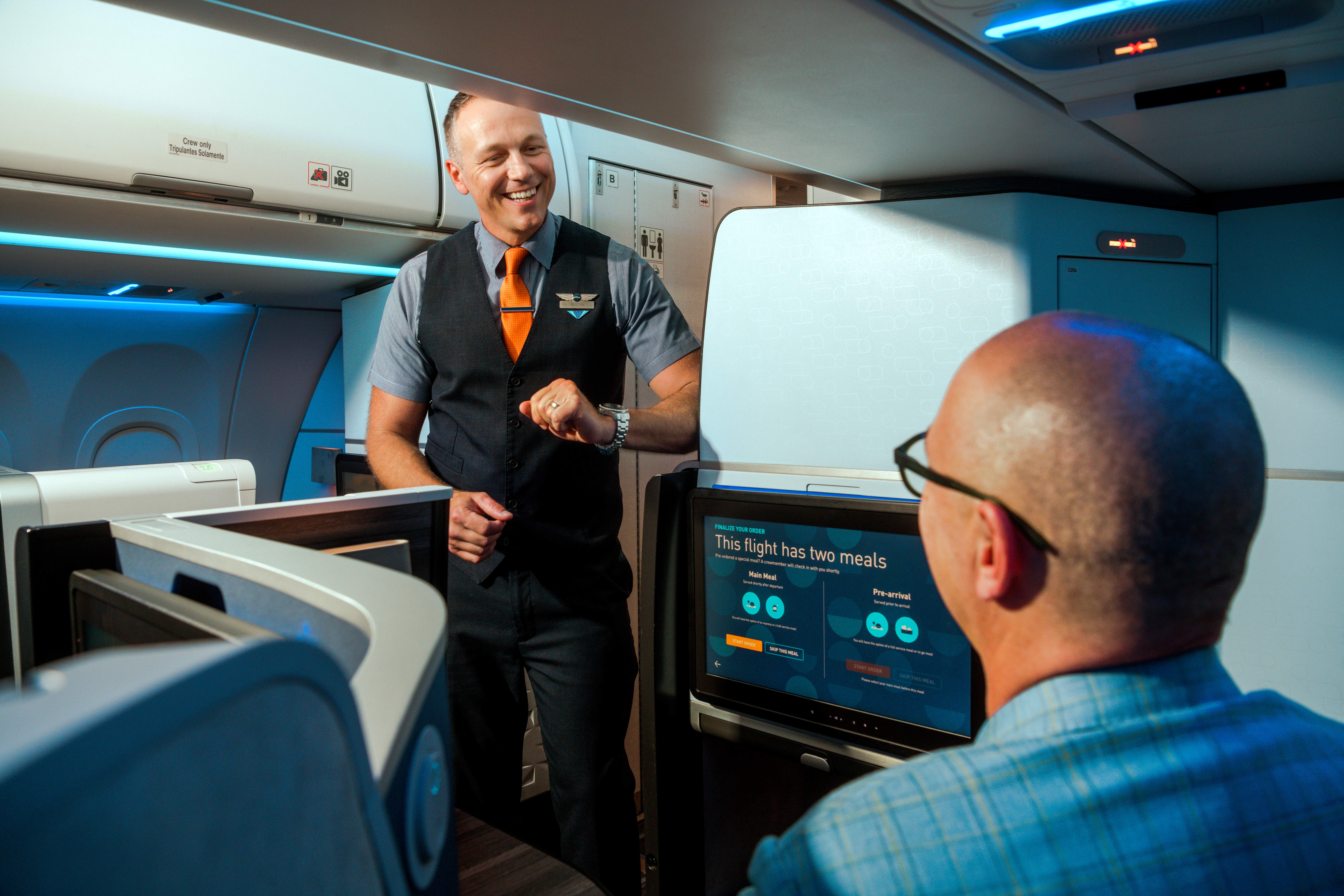a jetblue flight attendant serving a passenger in Mint