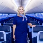 a southwest airlines flight attendant standing in the aisle of an airplane
