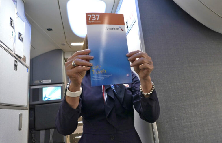 american airlines flight attendant holding up a safety card